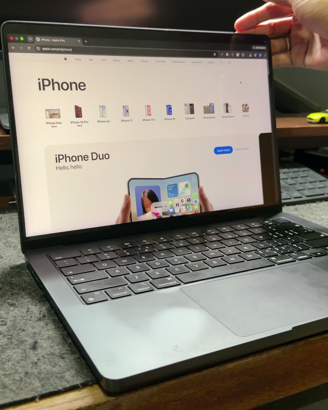 A MacBook with its lid open, showing a web page, just before Morphlet folds the screen away.